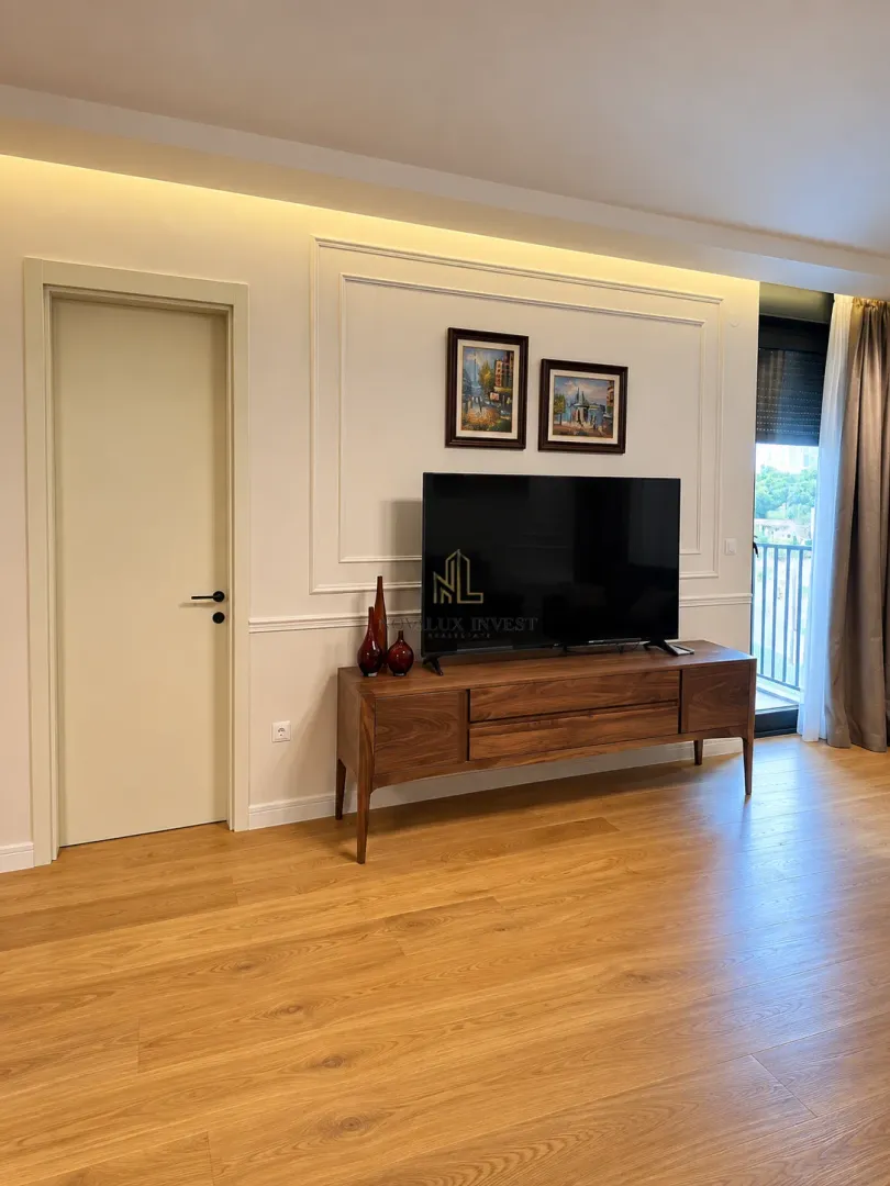 Living room with a wooden chest of drawers, TV, and wall art.