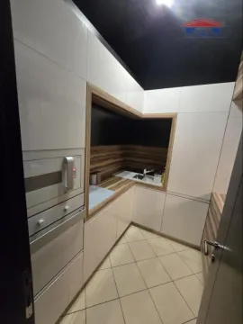 Moderna kuhinja sa belim elementima i ugrađenim kućnim aparatima. - image 9
