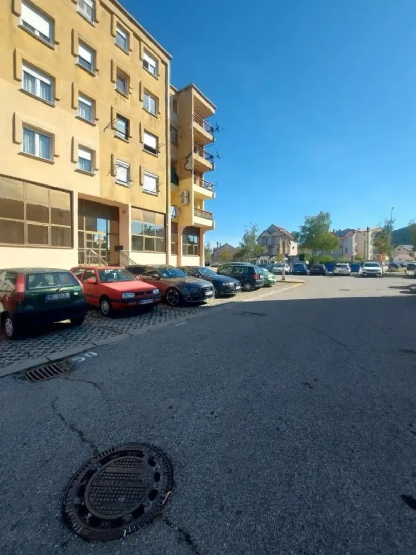Exterior view of an apartment building with parking in front.