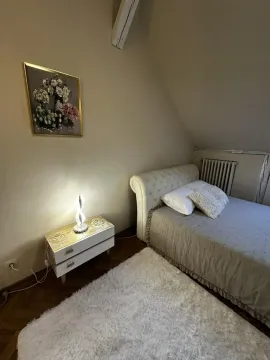 Manja spavaća soba sa krevetom, noćnim stočićem i slikom na zidu. - image 5