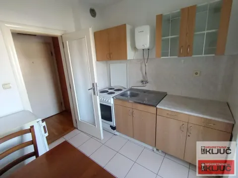 Smaller kitchen with wooden cabinets and a stove. - image 7