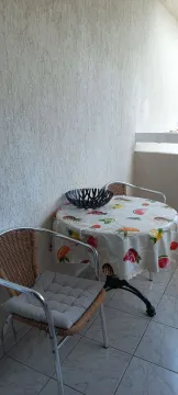 Small furnished balcony with a small table and two chairs. - image 7