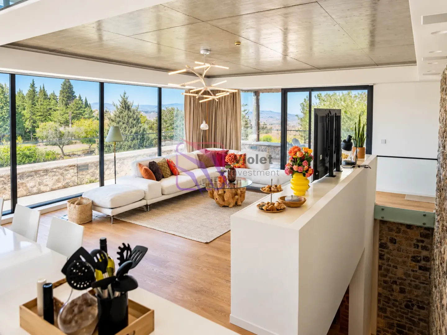 Spacious living room with large glass surfaces and nature views.