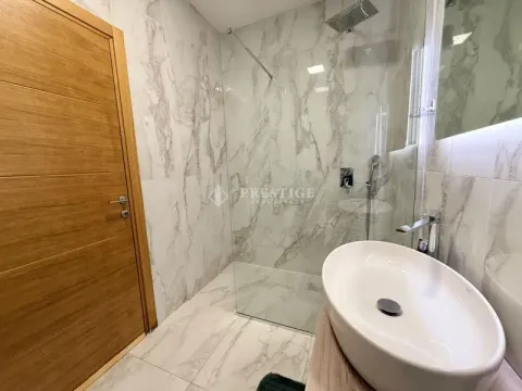 Modernly equipped bathroom with a walk-in shower and a sink. - image 14