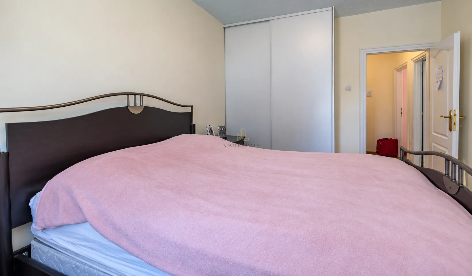 Bedroom with a double bed, wardrobe, and a view of the hallway.