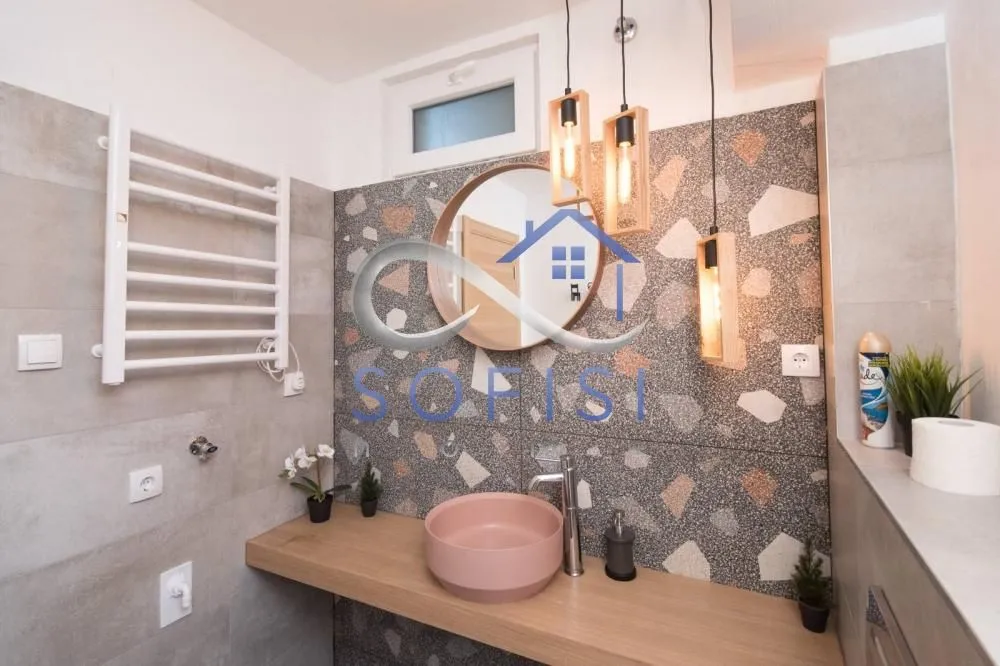 Modernly equipped bathroom with a washbasin and decorative tiles.