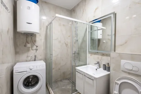 Moderno opremljeno kupatilo sa tuš kabinom, umivaonikom, veš mašinom i bojlerom. - image 16