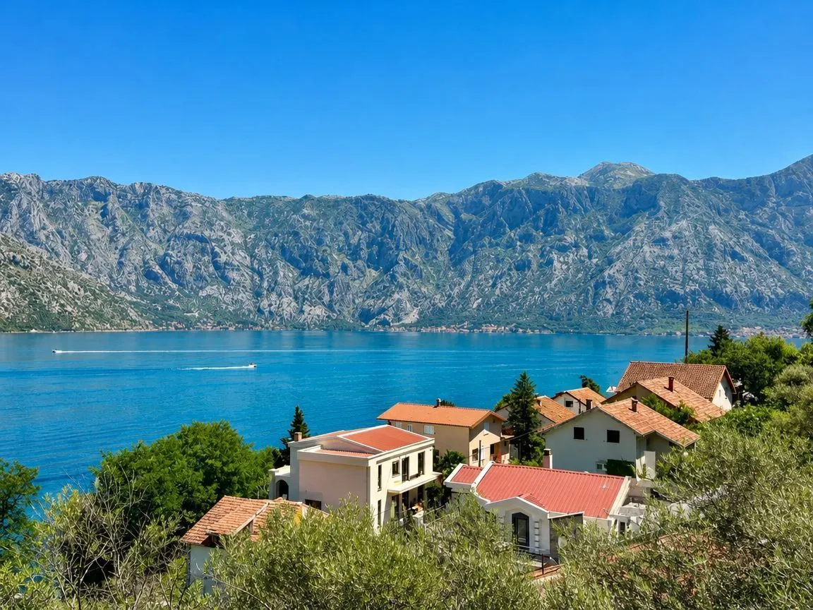 Pogled na zaliv i planine sa pogledom na kuće u naselju.