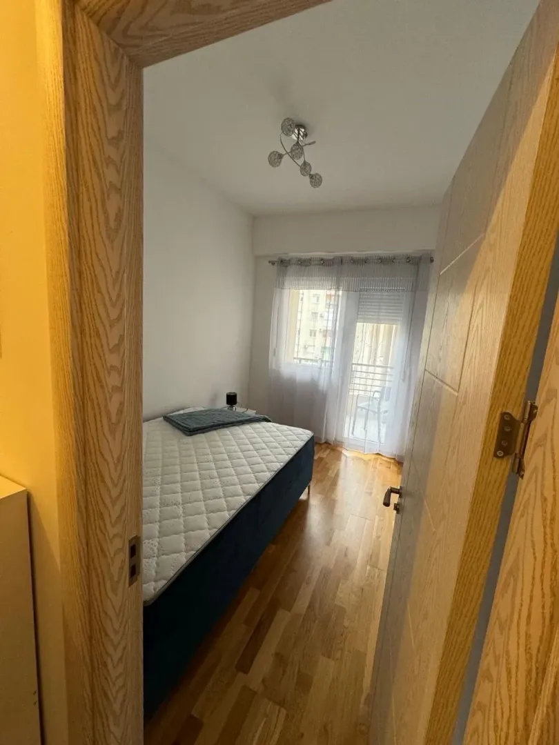 View from the hallway into a bedroom with a bed and access to the terrace.