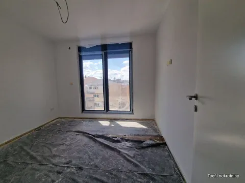 Prazna neuuređena prostorija sa prozorom i zaštitnom folijom na podu. - image 2