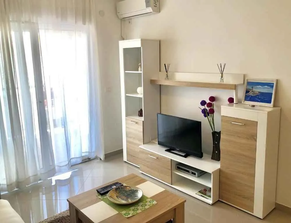 Svijetla dnevna soba sa TV regalom.