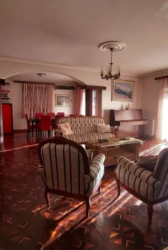 Spacious living room featuring a seating set, a piano, and a dining area in the background. - image 4