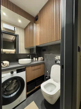 Modern bathroom with a washbasin, washing machine, and wooden wall panels. - image 9