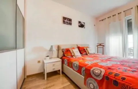 Furnished bedroom with a double bed, nightstand, and built-in wardrobe. - image 7