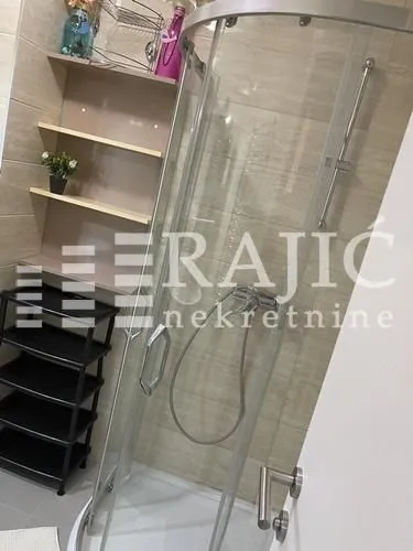 Bathroom with a shower cabin and shelving.