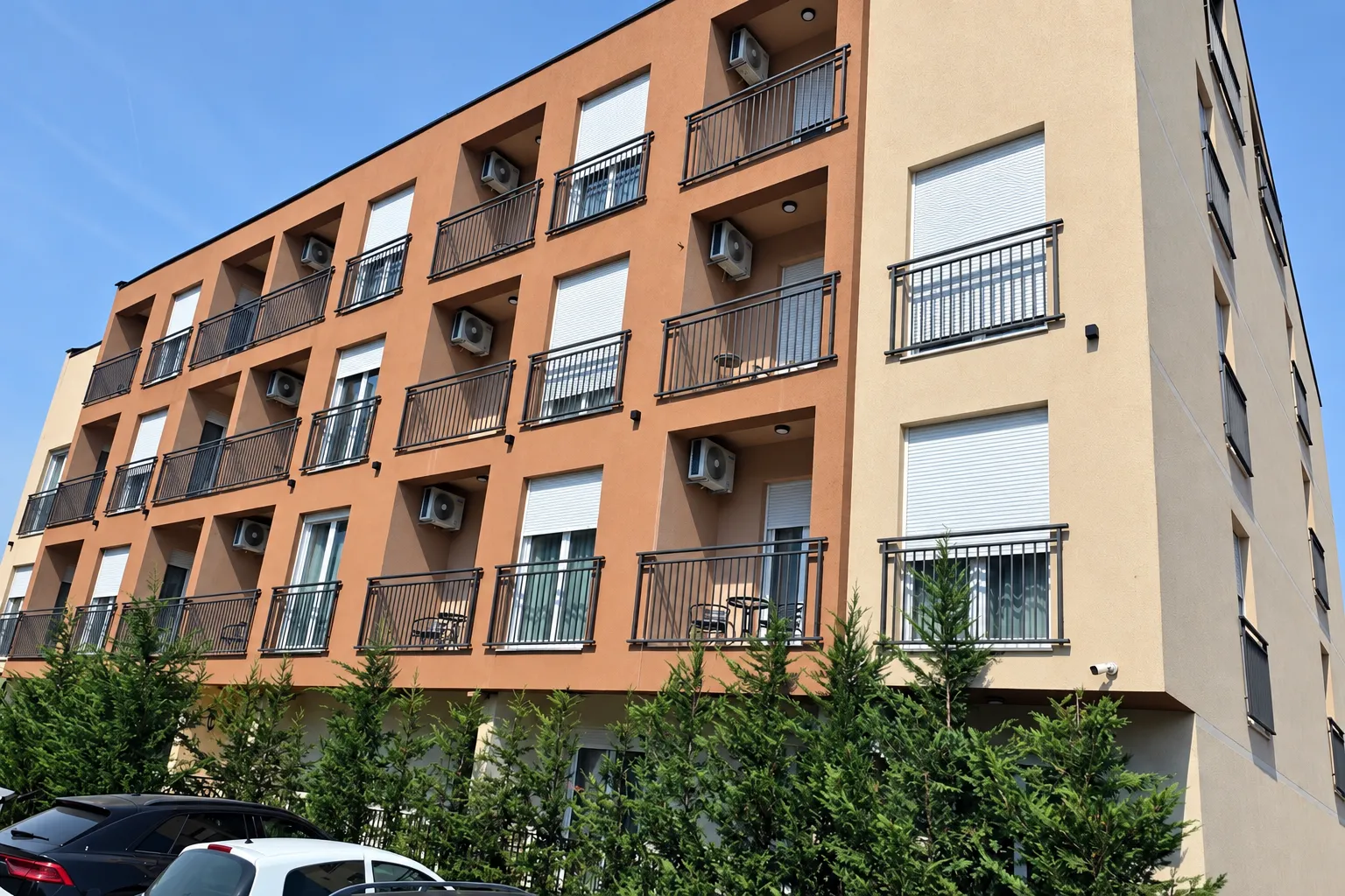 Spoljašnji izgled moderne višespratne zgrade sa balkonima i klima uređajima.