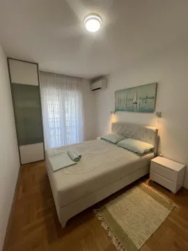 A bright bedroom featuring a double bed, wardrobe, and balcony access. - image 9