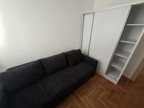 Pogled na tamnu ugaonu garnituru i beli ormar u dnevnoj sobi. - image 8