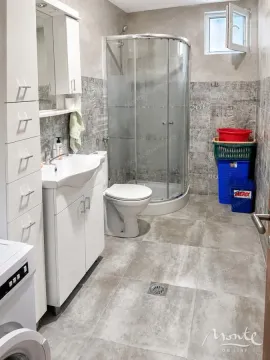 Kupatilo opremljeno tuš kabinom, umivaonikom, toaletom i bijelim ormarićima. - image 17