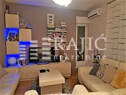 Living room furnished with a sofa set, TV unit, and bookshelves. - image 6