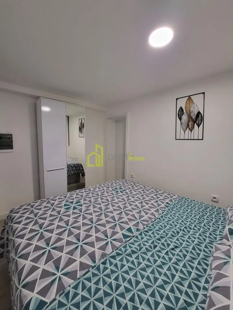 Furnished bedroom with a double bed and wardrobe.