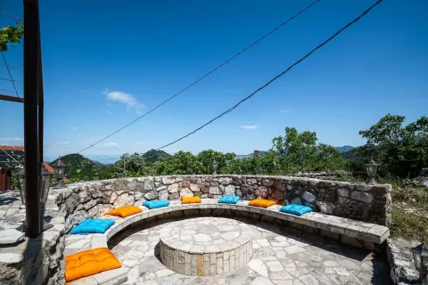 Kružna kamena klupa sa jastucima na terasi u dvorištu. - image 12