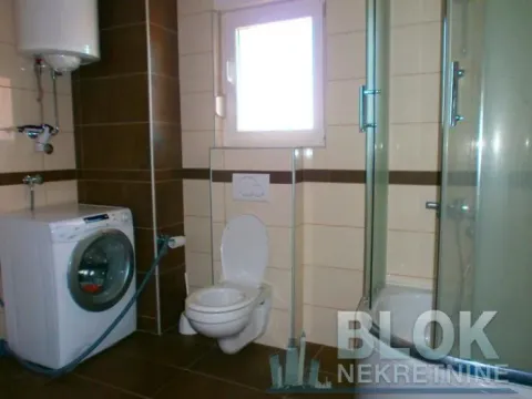 Bathroom equipped with sanitary facilities, a shower cabin, and a washing machine. - image 7