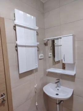 Pogled na kupatilo sa umivaonikom, ogledalom i radijatorom na zidu. - image 4