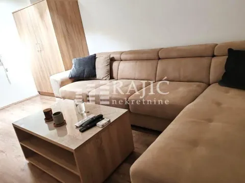 Living room with a large sectional sofa and a wooden coffee table. - image 2