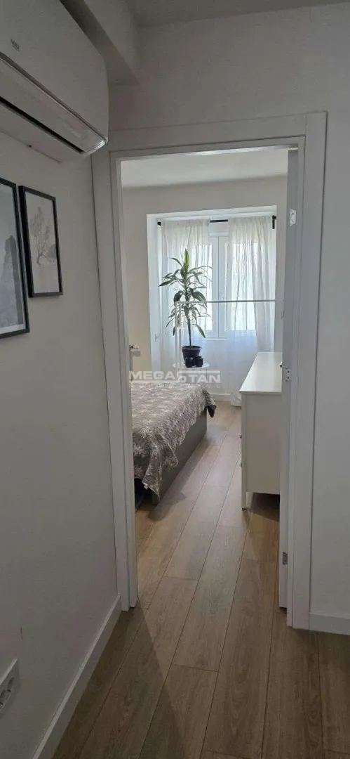 Pogled iz hodnika kroz vrata na nameštenu spavaću sobu.