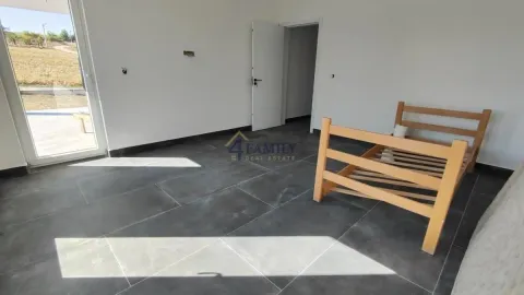 Empty room with dark floor tiles and a wooden bed frame. - image 2