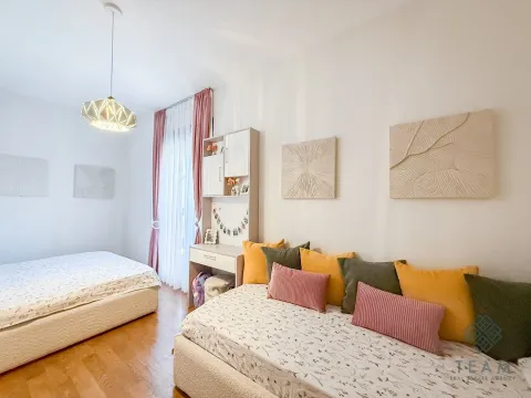 Bedroom with two beds, a desk, and decorative wall panels. - image 9