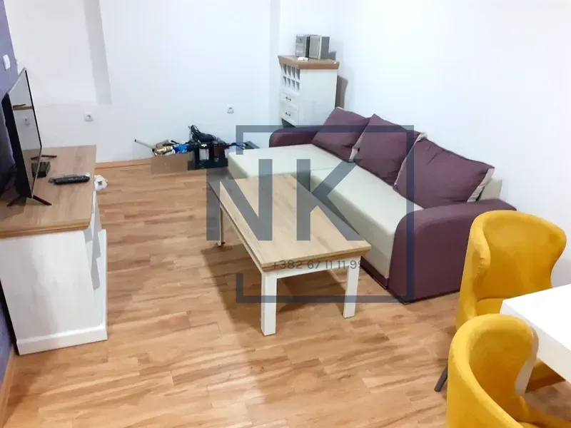 Dnevna soba sa garniturom, televizorom i klub stočićem.