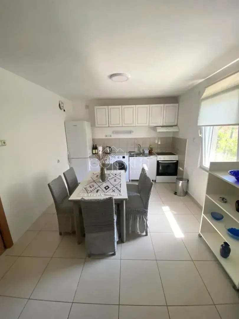 Small kitchen with a dining table and white cabinets.