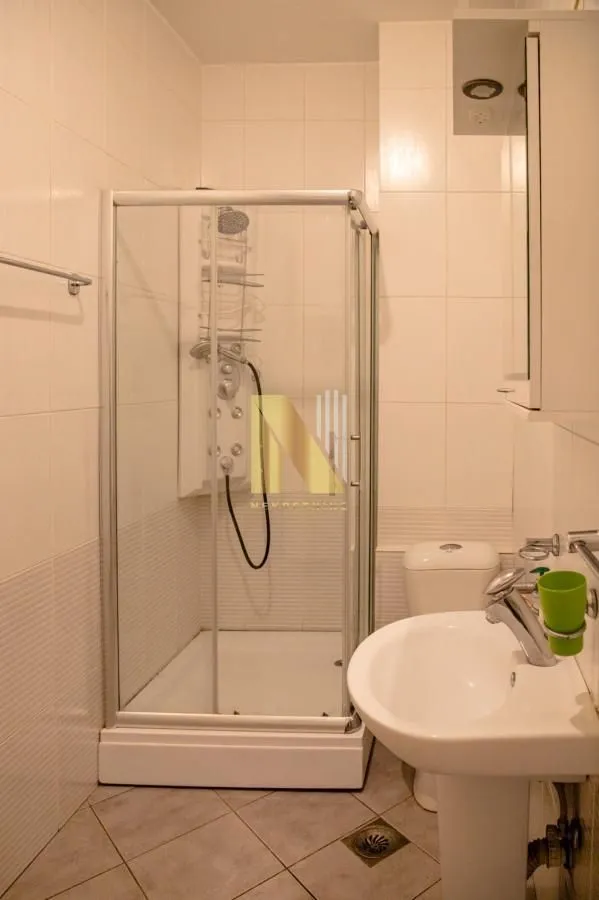 Manje kupatilo sa tuš kabinom, umivaonikom i toaletom.