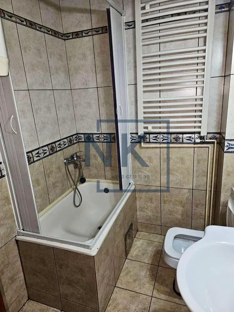 Bathroom equipped with a bathtub, washbasin, and towel radiator.