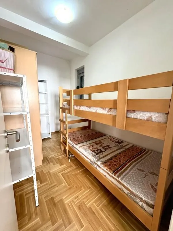 Small bedroom with a bunk bed and a wooden wardrobe.
