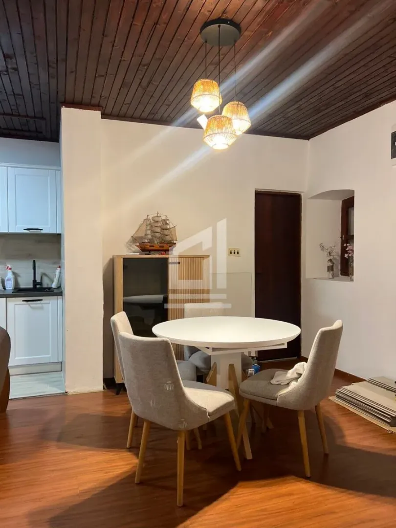 Dining area with a round table and chairs, connected to the kitchen.