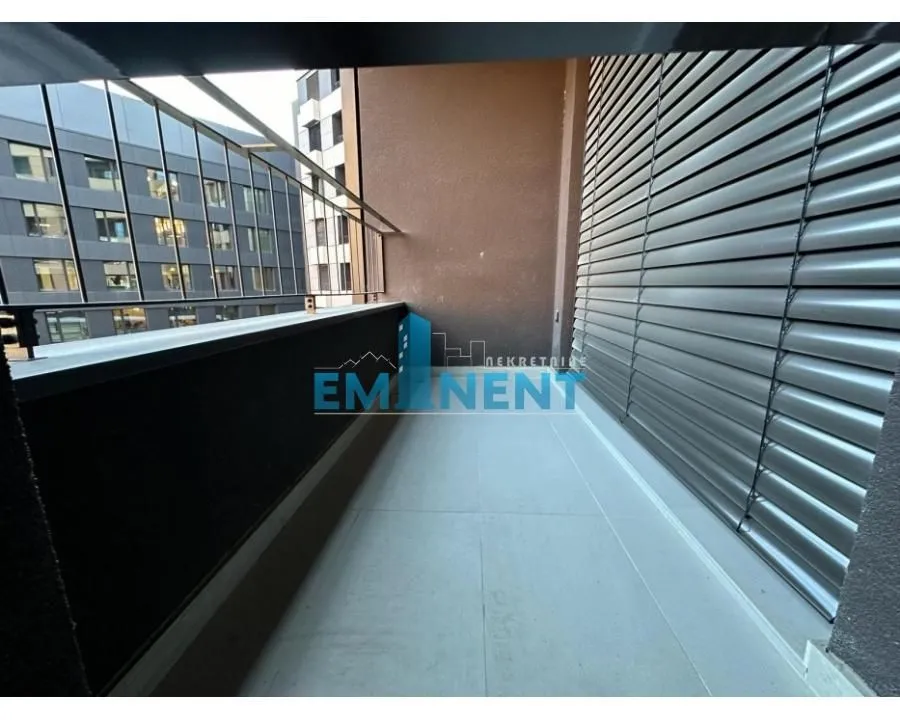 Covered balcony with a metal railing and a view of neighboring buildings.