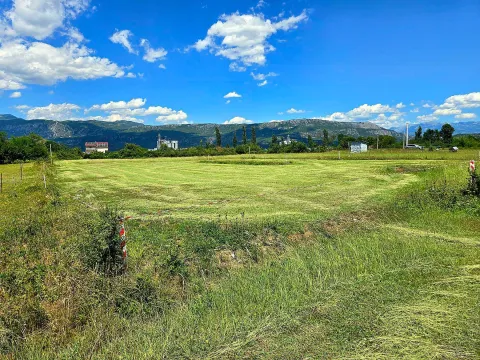 Pogled na zeleni plac sa travnjakom i planinama u pozadini. - image 5