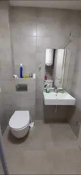 Simple bathroom with a toilet and a sink. - image 4