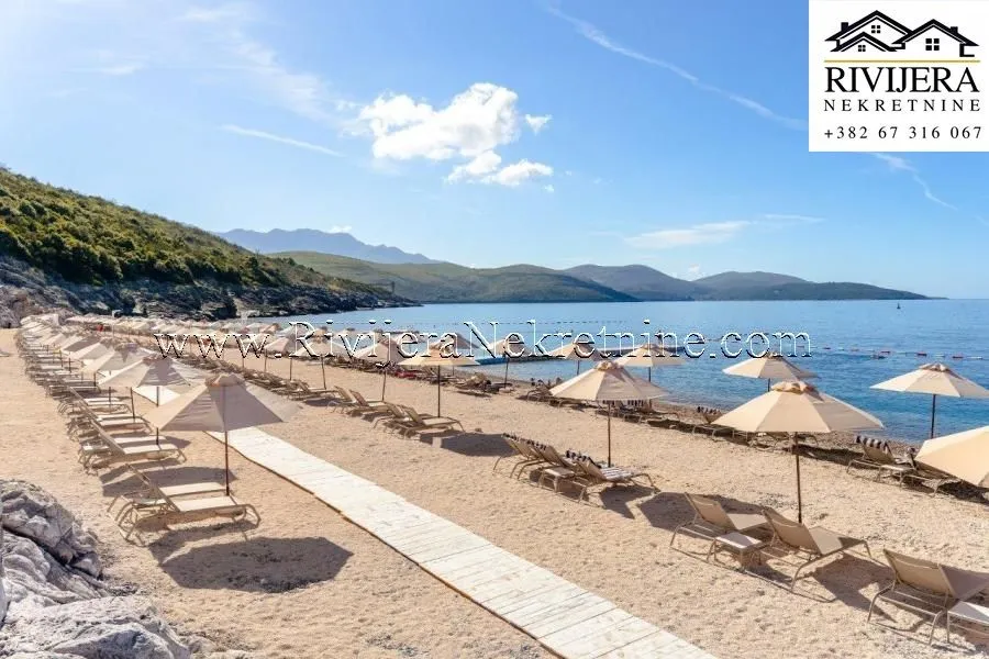 Plaža sa ležaljkama i suncobranima pored mora.