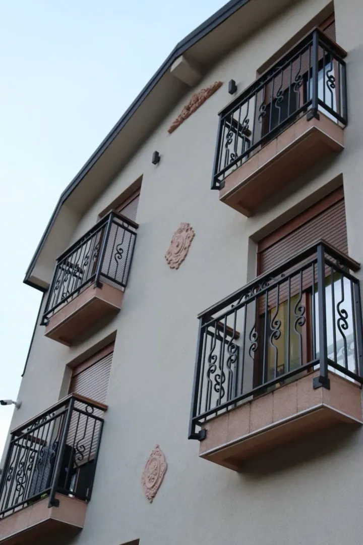 Fasada stambene zgrade sa balkonima od kovanog željeza.