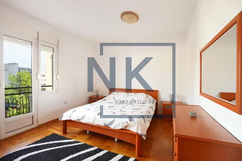 Bedroom with a double bed, wooden furniture, and access to a terrace.