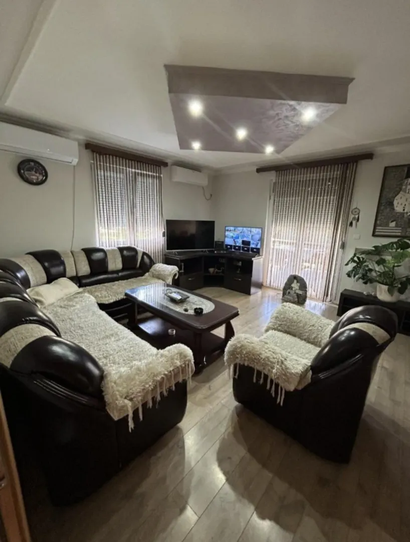 Spacious living room with seating set and TV.