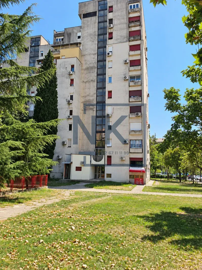 Exterior view of the residential building with a green lawn and trees.