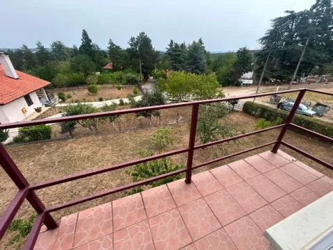 View from the tiled balcony overlooking the yard and surrounding greenery. - image 2