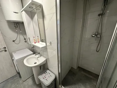 Moderno opremljeno kupatilo sa tuš kabinom, umivaonikom i veš mašinom. - image 18