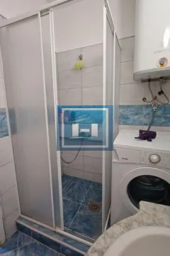 Bathroom with a shower cabin, water heater, and washing machine. - image 14