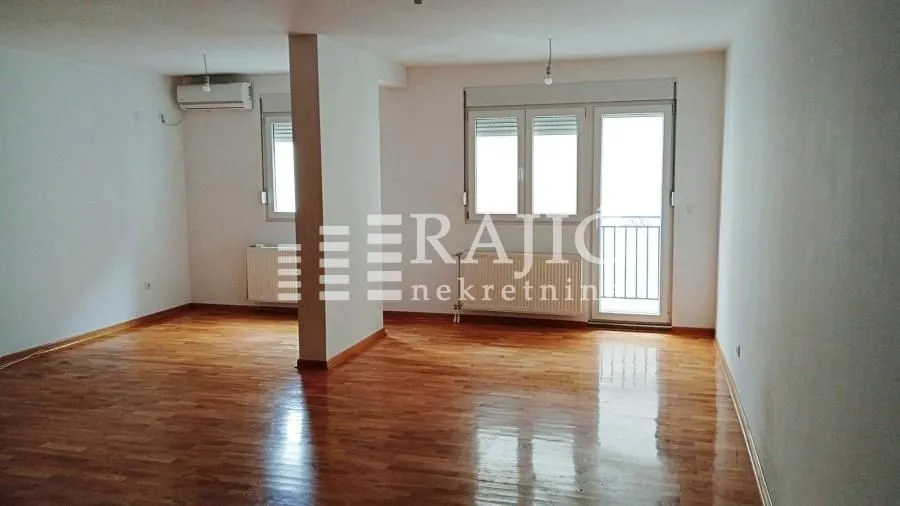 Empty living room with parquet flooring and access to the terrace.
